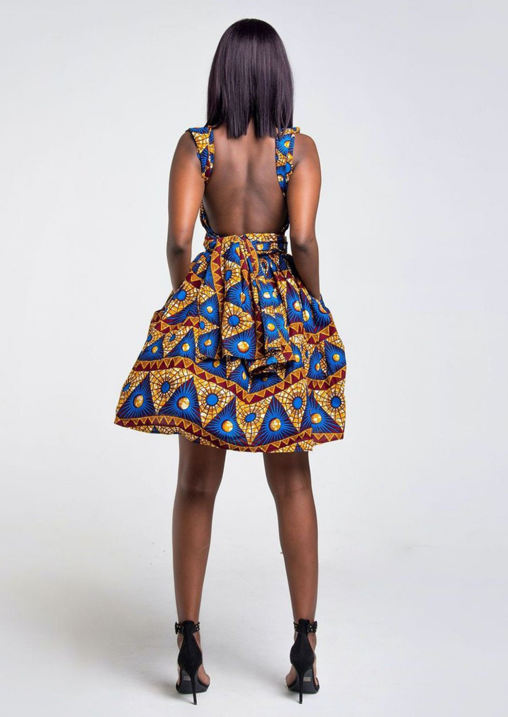 A blue African print multiway midi dress, our model wears the Ankara dress in blue, gold and red as a backless dress.