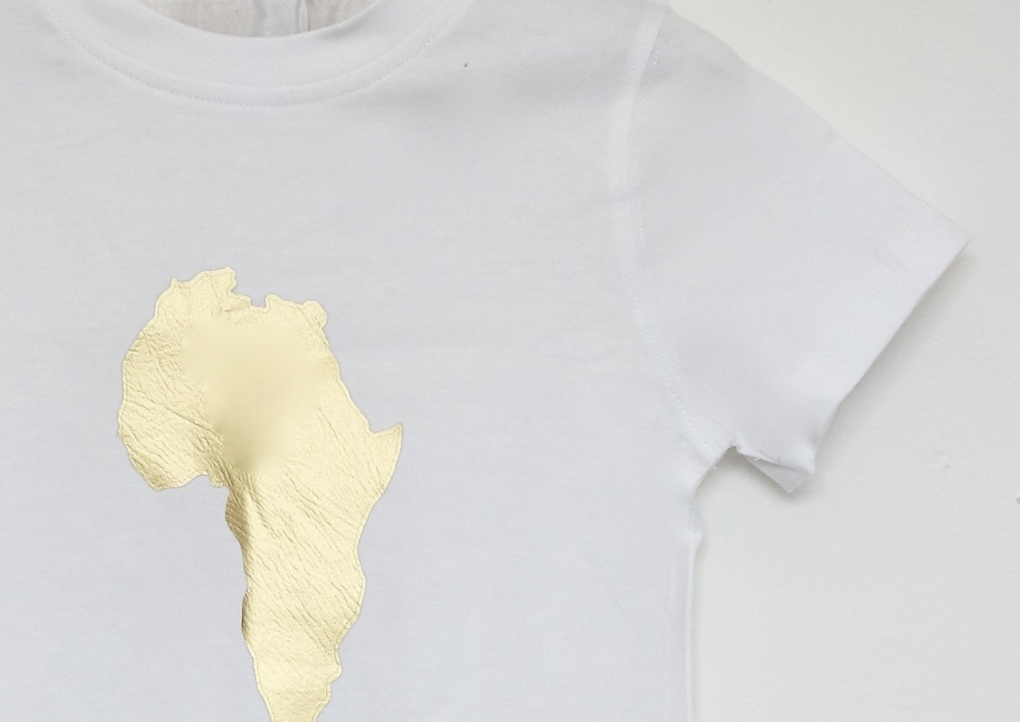 A cute boy's white short sleeve t-shirt with gold map of Africa graphic on the centre.