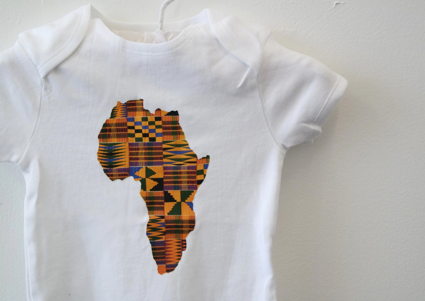 Our unisex baby bodysuit makes this garment the ideal boys baby grow or girls baby grow. The kente print map of Africa makes a unique baby romper suit for all occasions.