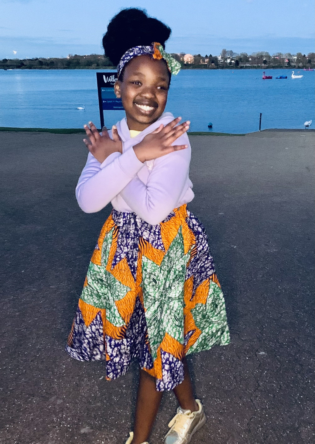 Orange African print a-line girls skirt with purple and green floral motif.