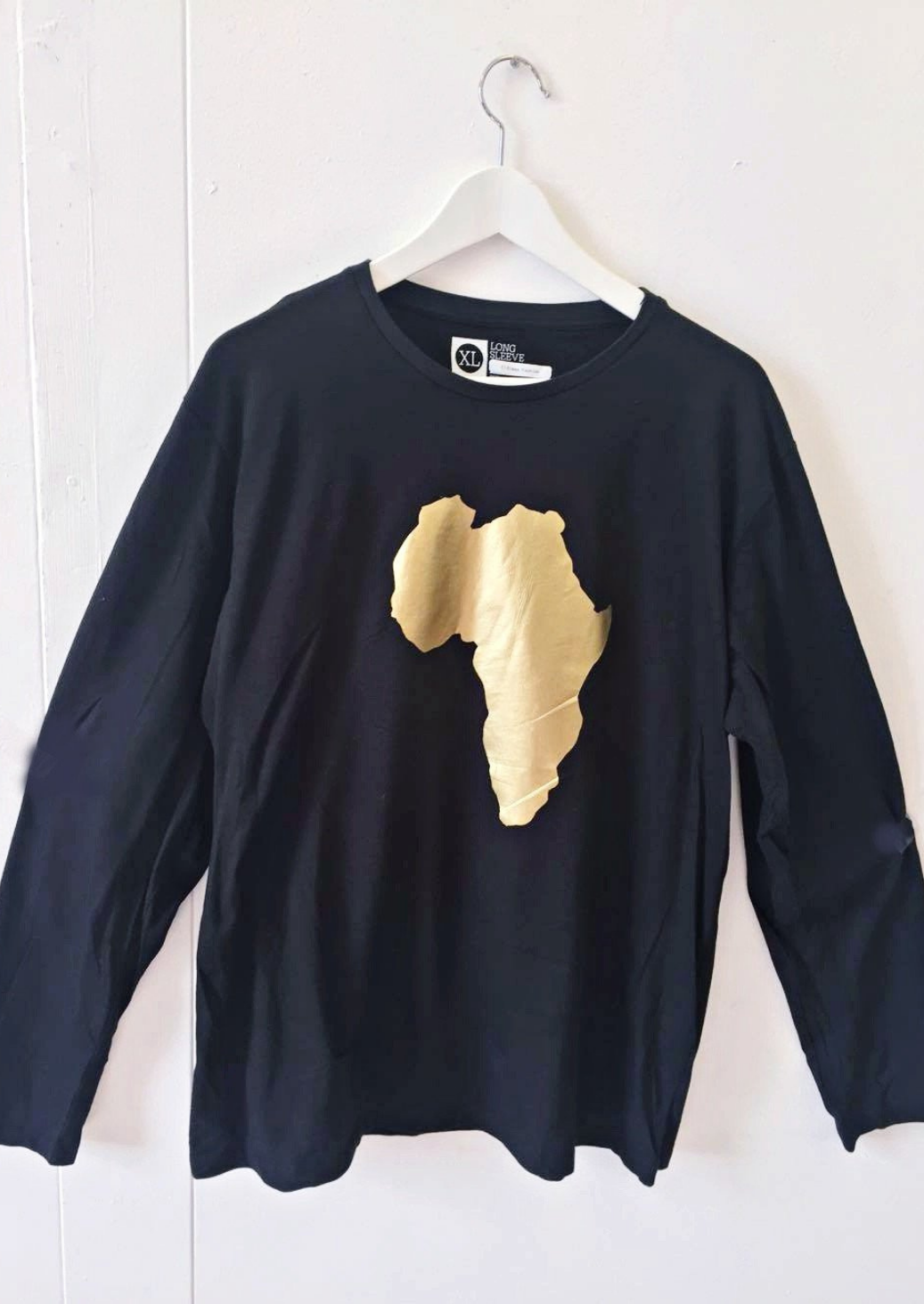 The men's black long sleeve top with round neckline and gold map of Africa graphic.