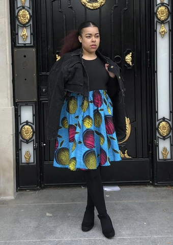 A light blue midi skirt with bold African print. The pleated midi skirt has pops of pink and yellow, making a statement African print dress.