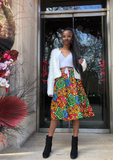 The Folu, a beautiful African print skirt, with tones of red, green, blue and yellow. The pleated midi skirt is bright and vibrant, the patchwork print making a beautiful flared skirt.